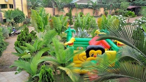Un jardin doté de structures de jeux gonflables et d’une végétation luxuriante.