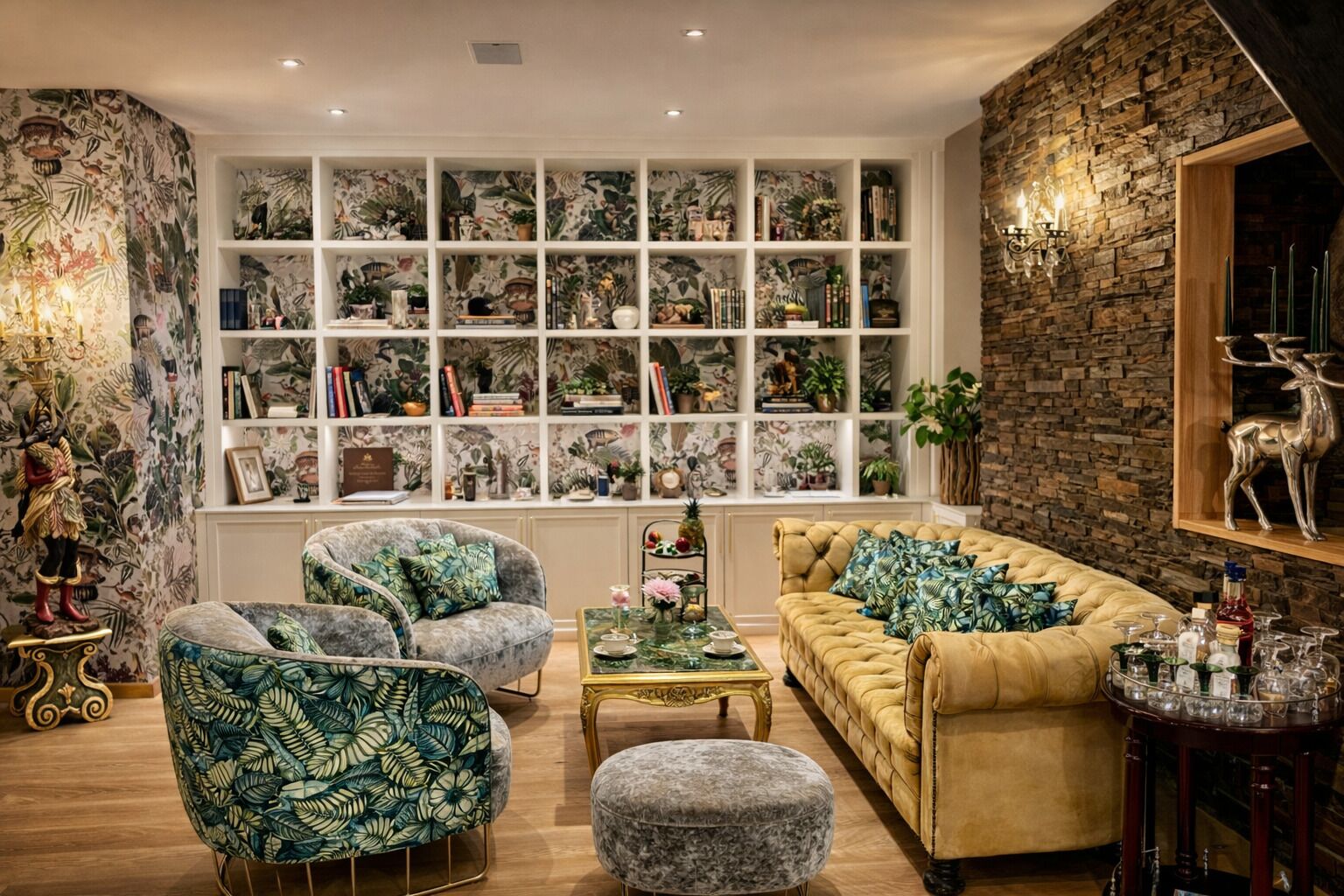 A cozy living room with a large bookshelf, plush seating, and a stone wall.