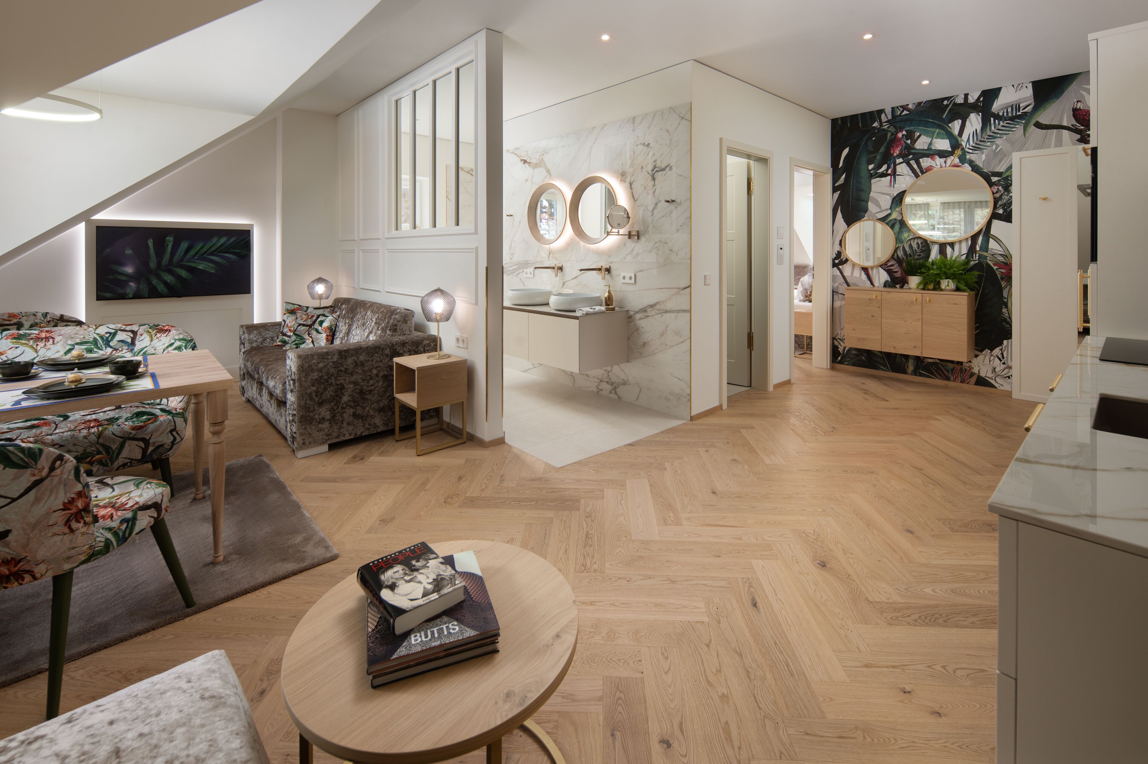 Un salon moderne avec un canapé, une table à manger et une table basse. Il y a aussi une salle de bain avec un miroir et un lavabo.