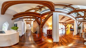 A spacious interior with a curved kitchen island, wooden beams, and a polished wooden floor. - Schlossresidenz Boutique Apartements & Hotel Suiten (Garbsen)