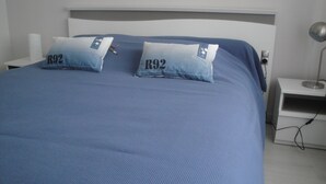 A bed with two pillows labeled "R92" and a bedside table with a lamp. - Bright house with garden and terraces. (Concarneau)