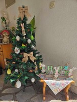 Un árbol de Navidad con adornos y una mesa con un cartel que dice 'Feliz Pascua'.