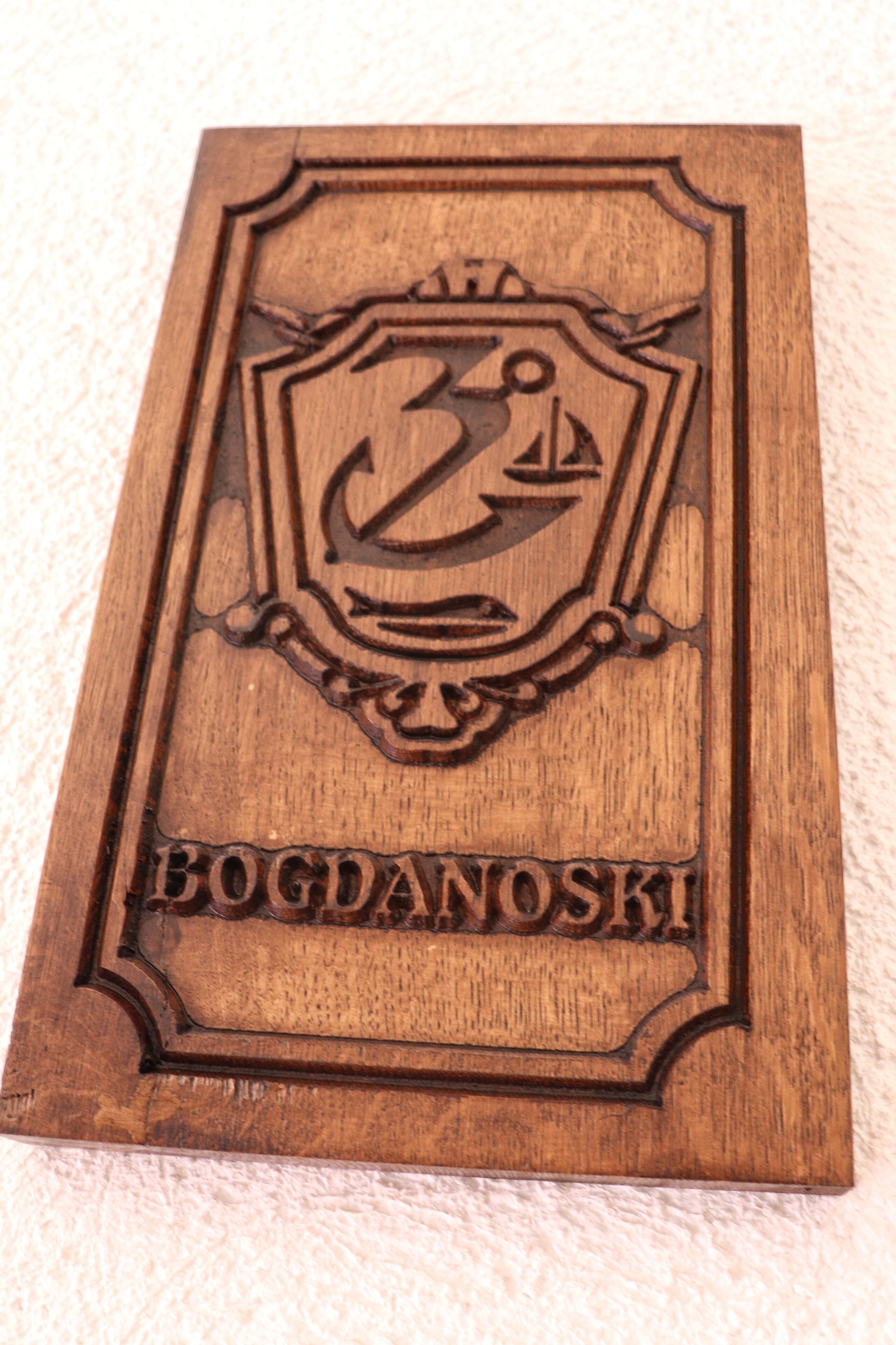 Una placa de madera con un emblema de ancla y el texto "BOGDANOSKI".
