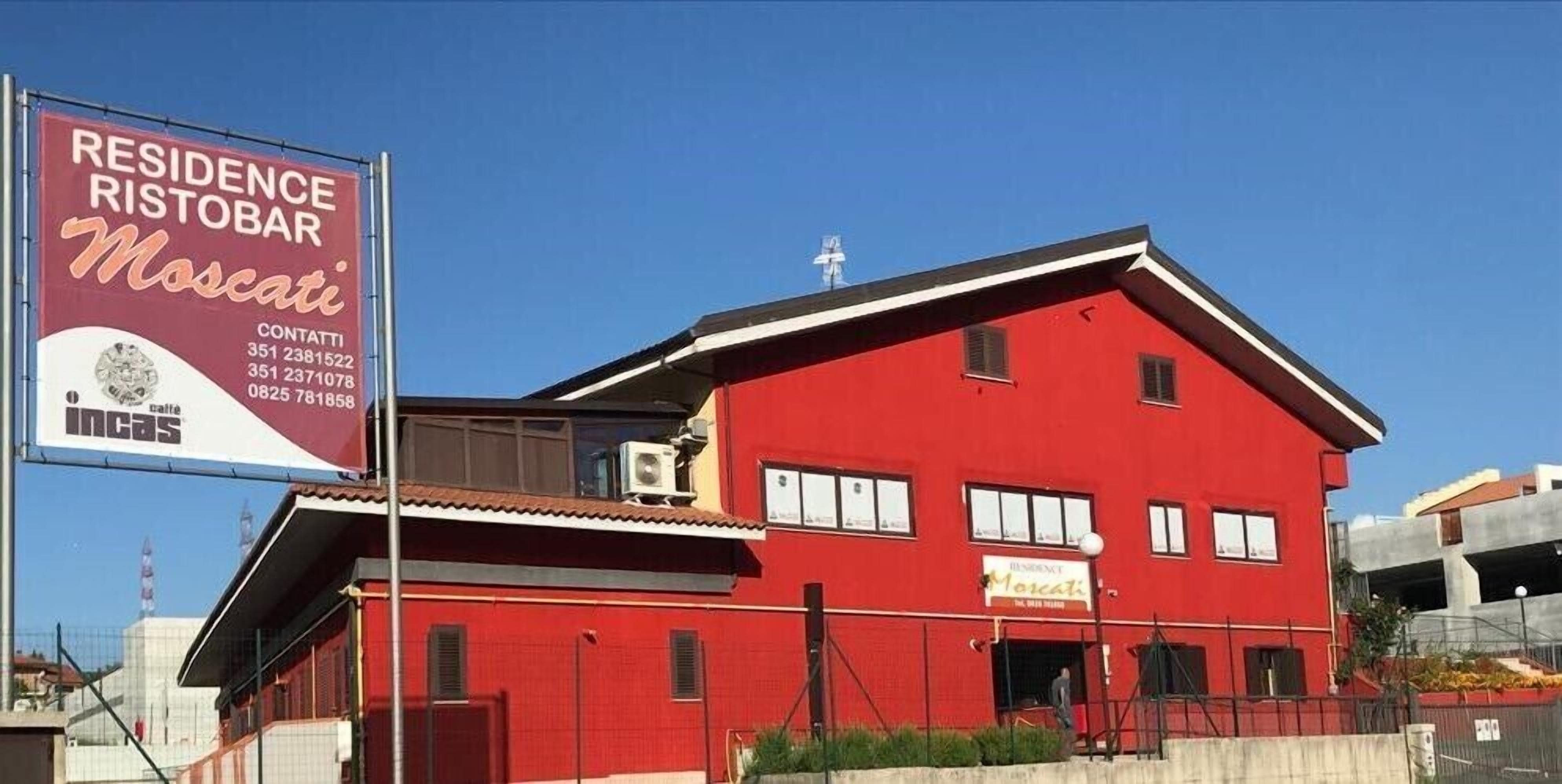Ein rotes Gebäude mit einem Schild für 'Residence Ristobar Moscat'.
