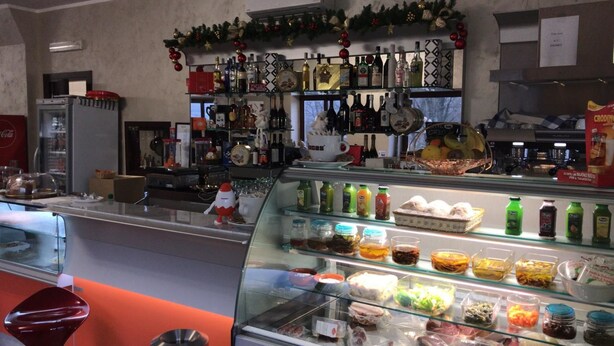 A restaurant with a glass display case filled with various food items. - Residence Moscati (Avellino)