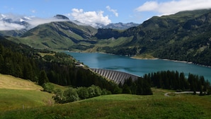 A mountainous landscape with a lake and a dam.