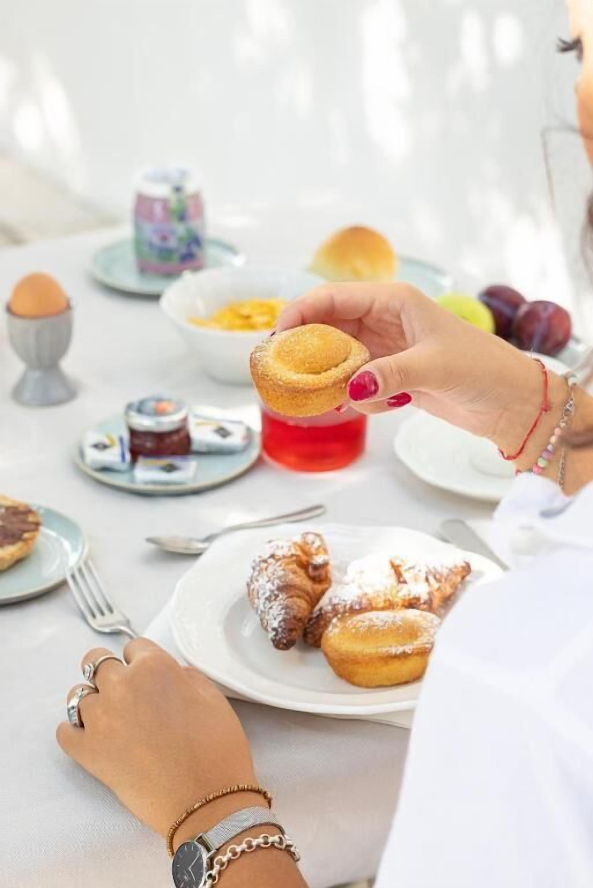 Una mesa de comedor con diversos alimentos, entre ellos pasteles y una bebida roja.
