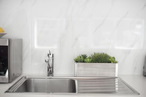 Een koelkast met diepvriezer, een microgolfoven, een kookplaat