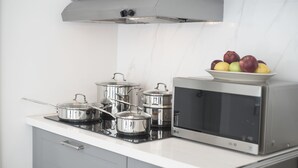 A kitchen with stainless steel appliances, including pots, a microwave, and a toaster oven. - Sobe Lux (Miami Beach)