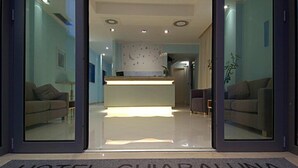 A hotel entrance with a reception desk, sofas, and a clear view of the interior. - Hotel Chiaraluna (Civitanova Marche)
