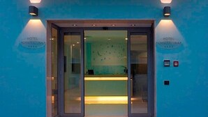 The entrance to Hotel Chiaraluna with a glass door and a reception desk inside. - Hotel Chiaraluna (Civitanova Marche)