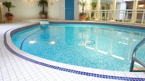 An indoor swimming pool with tiled flooring and potted plants. - Red Lea Apartments (Scarborough)