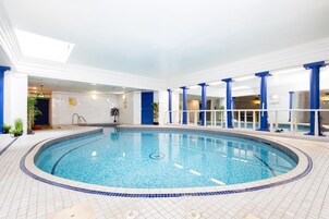 Una piscina techada, sillones reclinables de piscina