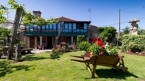 A two-story house with a garden in front. - Casa de Marcelo (Padron)