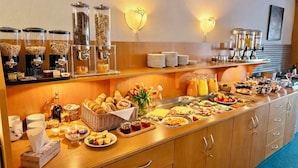 A buffet with various food items, including fruits, pastries, and beverages. - Turmhotel Schwedt (Schwedt/Oder)