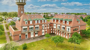 A large brick building with multiple windows and a tower. - Turmhotel Schwedt (Schwedt/Oder)
