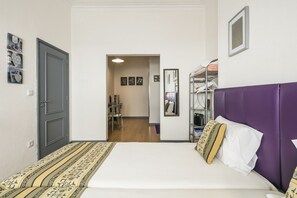 Una camera da letto con un letto, un armadio, uno specchio e una porta.