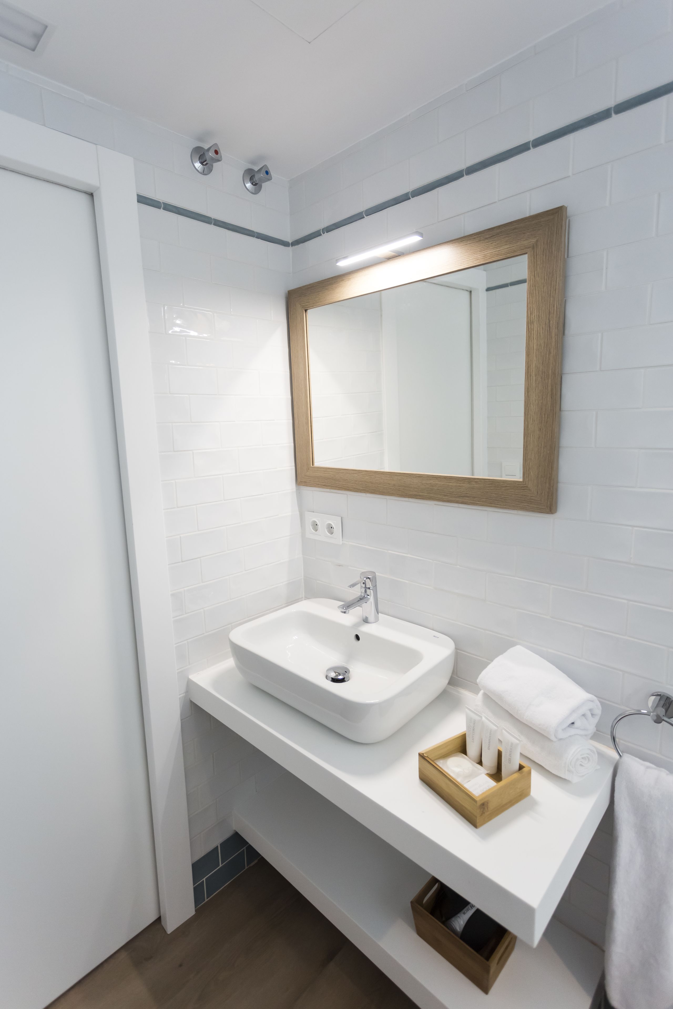 A bathroom with a white sink, mirror, and towel rack.