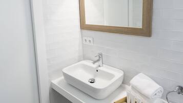 A bathroom with a white sink, mirror, and towel rack.