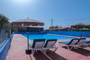 室外游泳池，池畔遮阳伞，日光浴躺椅