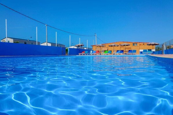 室外游泳池，池畔遮阳伞，日光浴躺椅