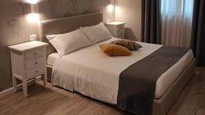 Ein ordentlich eingerichtetes Schlafzimmer mit Bett, Nachttischen und einem Nachtschränkchen.