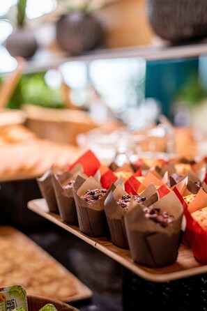 Un buffet proposant une variété de plats, notamment des cupcakes et un assortiment de pâtisseries.