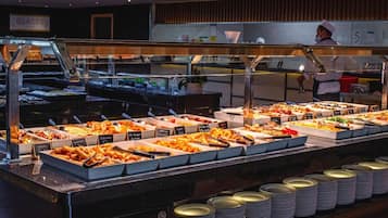 A buffet with various food options and serving utensils.