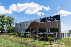 Un restaurant Seazen doté d’une terrasse et d’une enseigne bien visible indiquant l’hôtel Woods.
