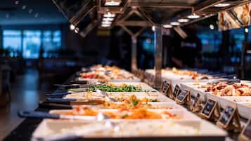 A buffet with various food options and serving utensils.