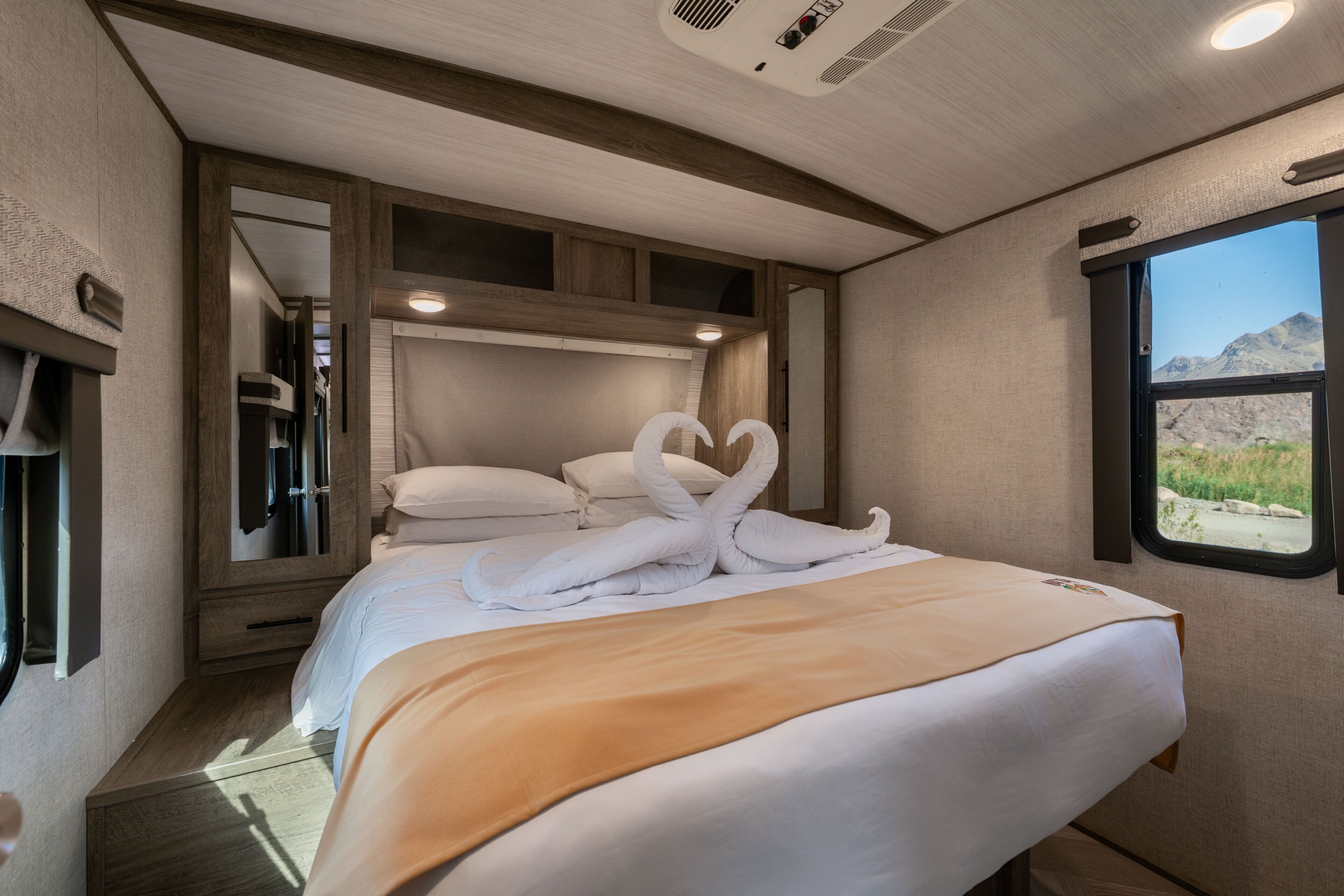 Un dormitorio con cama, ventana y espejo.