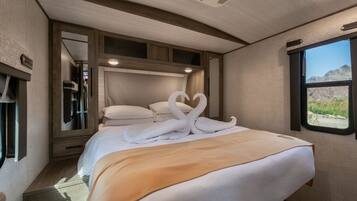 Un dormitorio con cama, ventana y espejo.