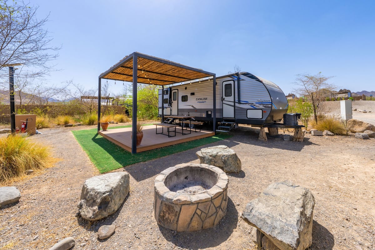 A Catalina RV with a covered outdoor area, a fire pit, and a patio.