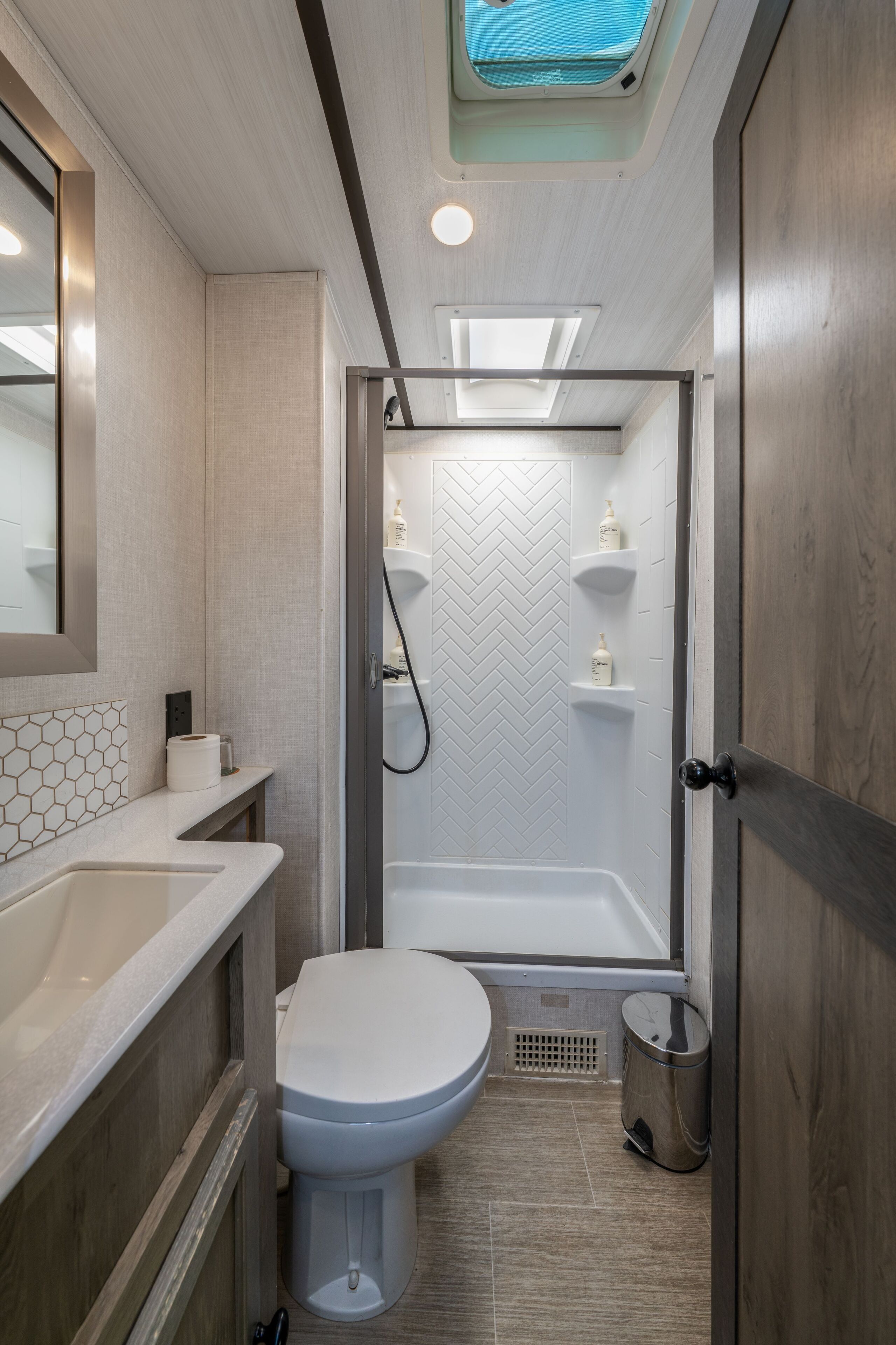 A compact bathroom with a shower, toilet, and sink.