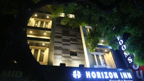 A building with a sign for "Horizon Inn Executive Rooms" and a visible coffee shop named "MID Coffee." - Horizon Inn (Chennai)