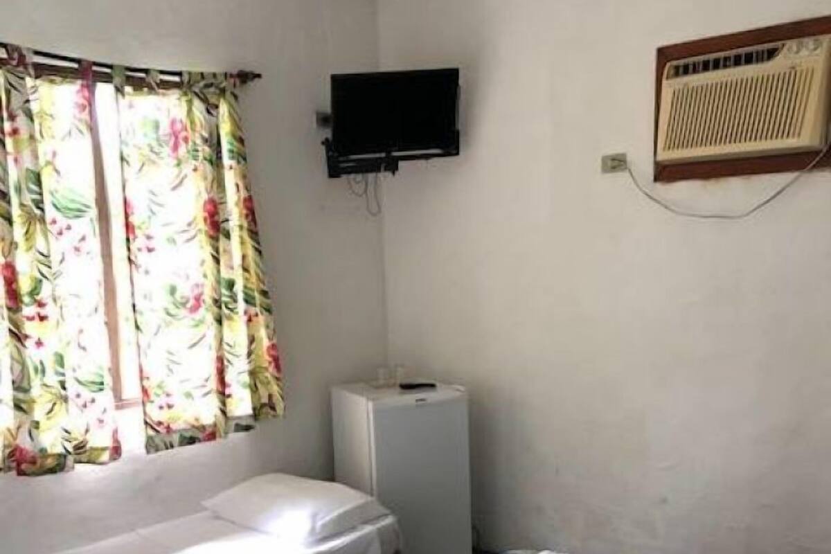 Ein Zimmer mit zwei Betten, einem Fernseher und einer Heizung.