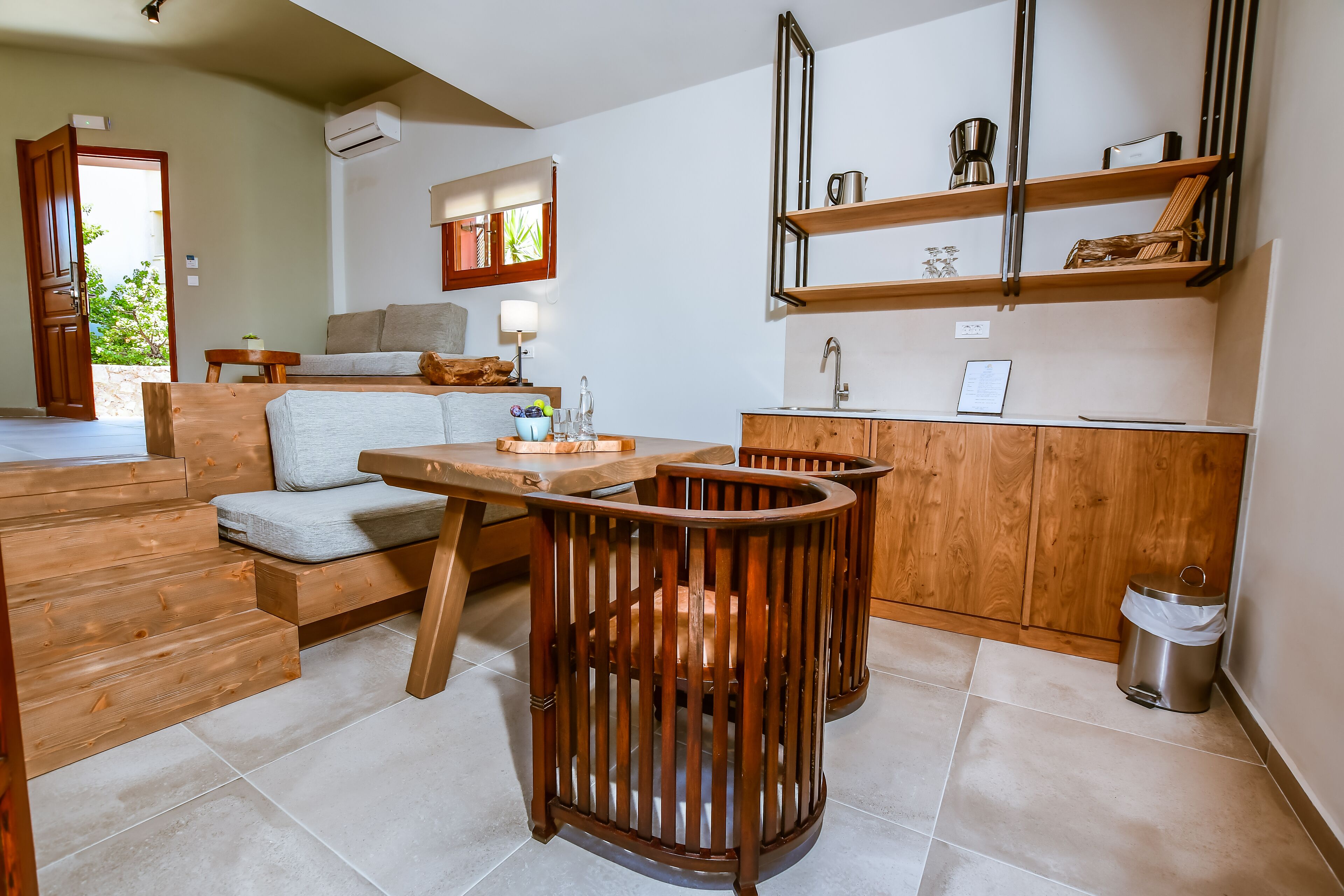 Une cuisine moderne avec des meubles en bois, un évier encastré et un coin repas comprenant une table et des chaises en bois.
