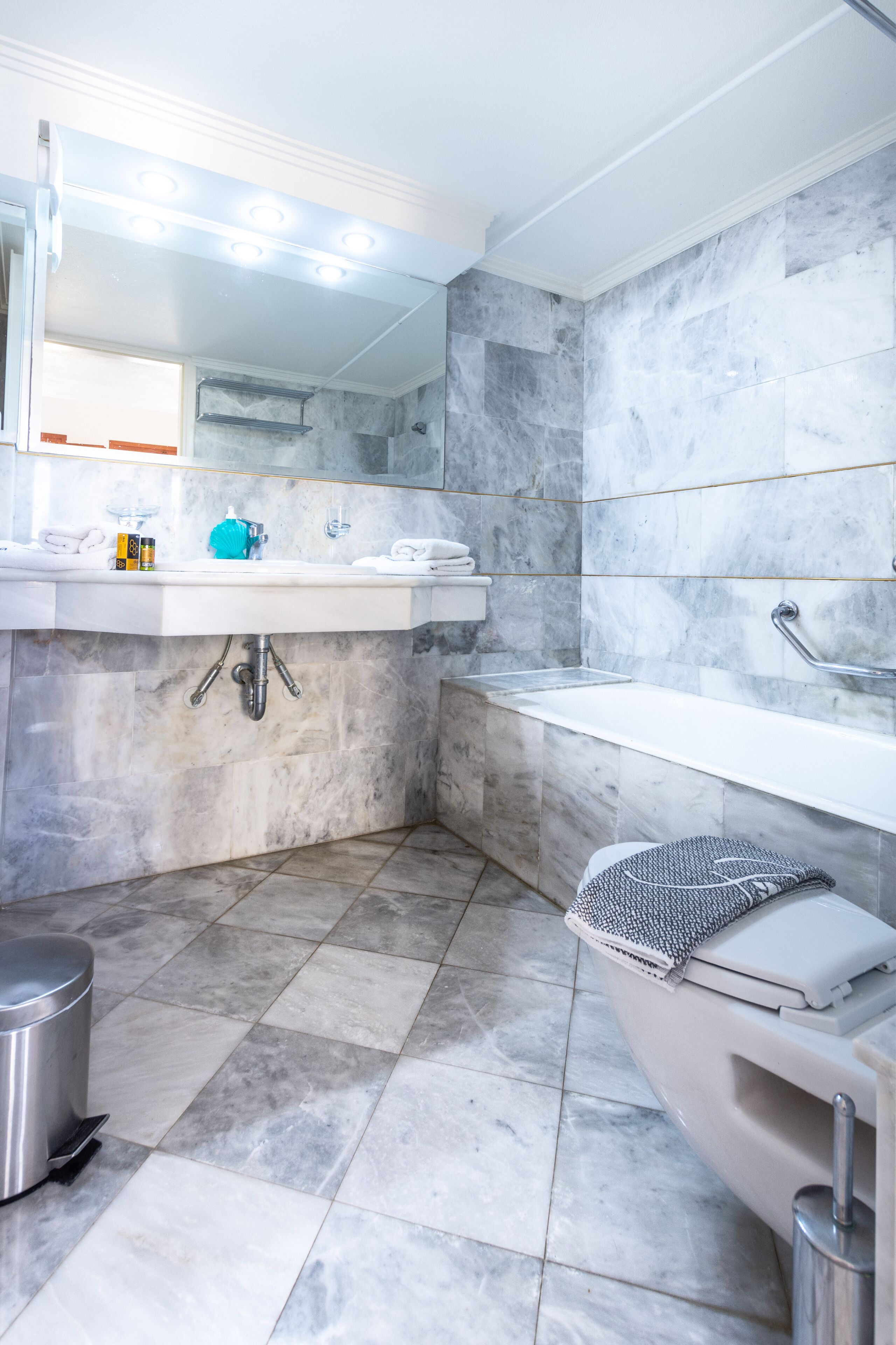 A modern bathroom with a white sink, a bathtub, and a shower.