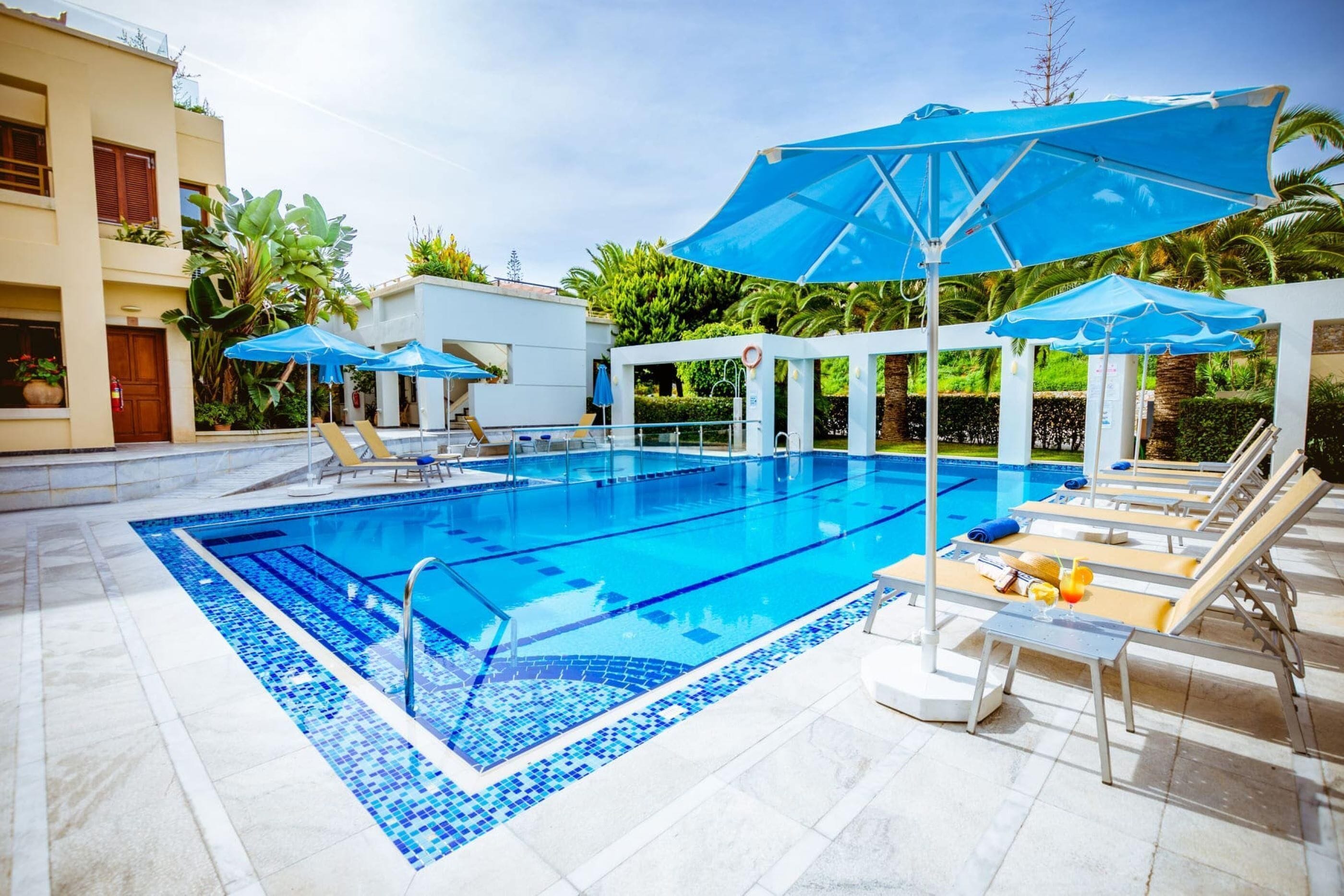 Una piscina al aire libre de temporada, sombrillas