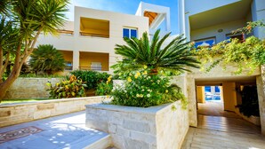 A modern building with a courtyard, stone steps, and lush greenery. - Anais Collection Hotels & Suites by GHH (Chania)