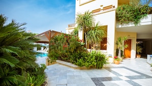 A courtyard with a pool, potted plants, and a tiled floor. - Anais Collection Hotels & Suites by GHH (Chania)