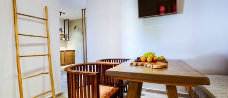Un comedor con una mesa de madera, sillas y un frutero.