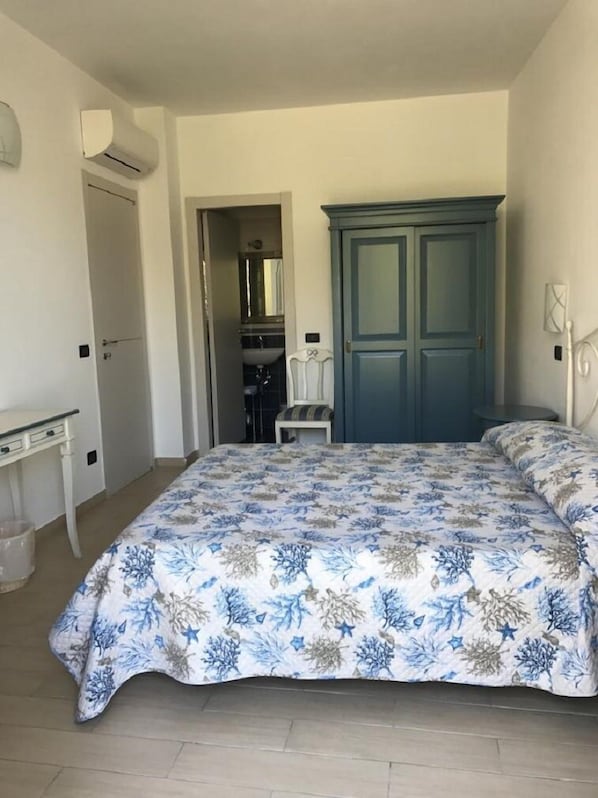 A bedroom with a bed, a dresser, a chair, and a wardrobe. - Sandra Villa Rooms (Vernazza)