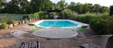 Piscine extérieure en saison, chaises longues