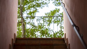 A staircase with a metal handrail leading to a balcony with a view of trees. - B&B With Pool and View of Assisi (Assisi)