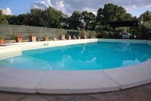 Una piscina al aire libre de temporada, tumbonas