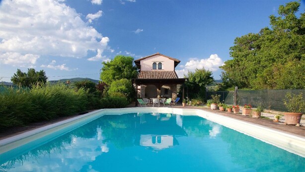 A swimming pool with a house in the background. - B&B With Pool and View of Assisi (Assisi)