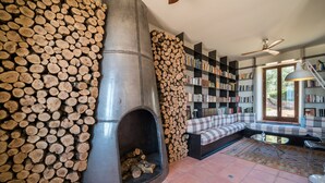 A cozy living room with a fireplace, a bookshelf, and a seating area. - Cortijo LA Almazara (Ronda)