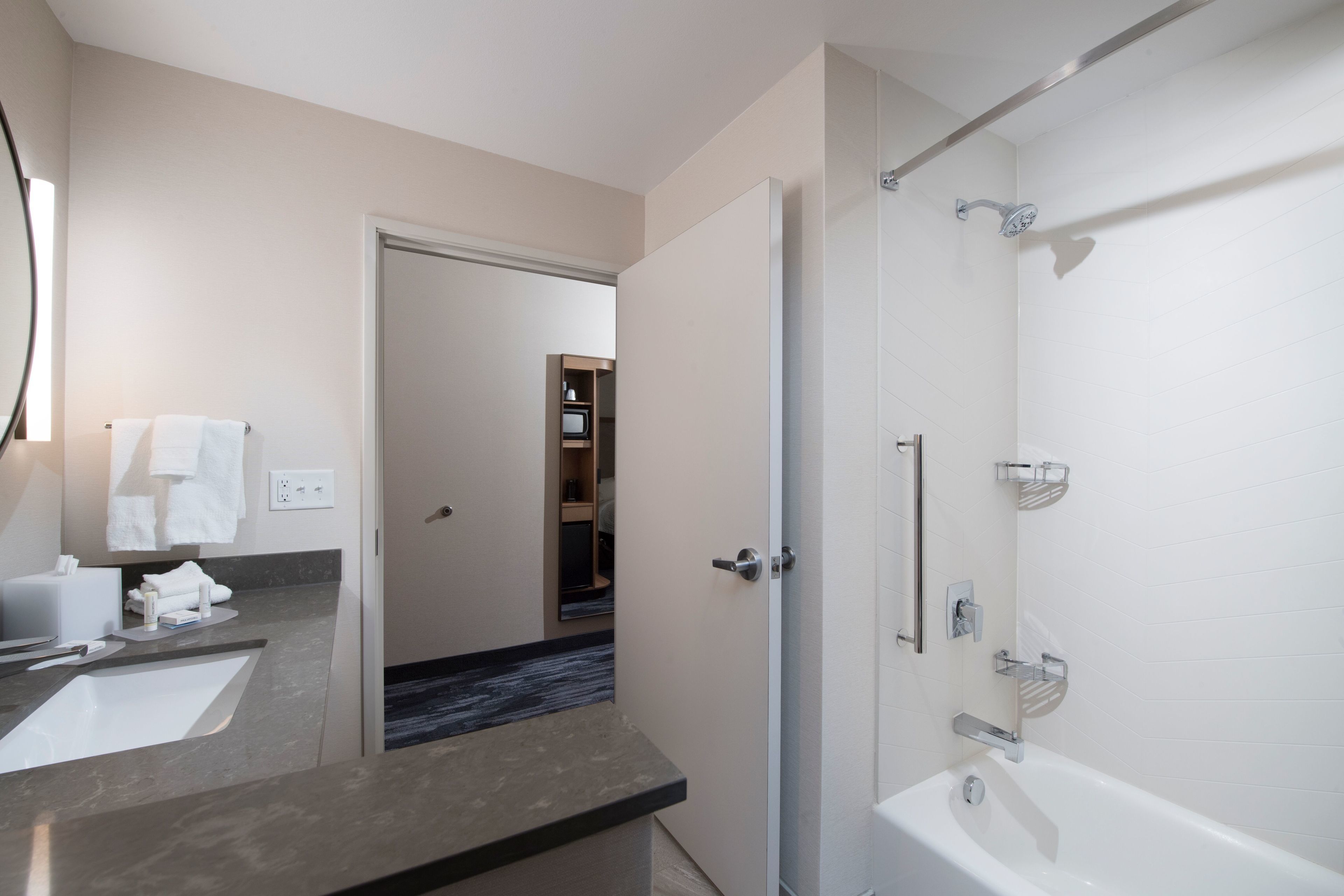 Une salle de bain moderne avec un grand lavabo, un miroir et une douche.