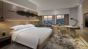 Une chambre d’hôtel moderne équipée d’un grand lit, d’un bureau, d’une chaise et d’une télévision.